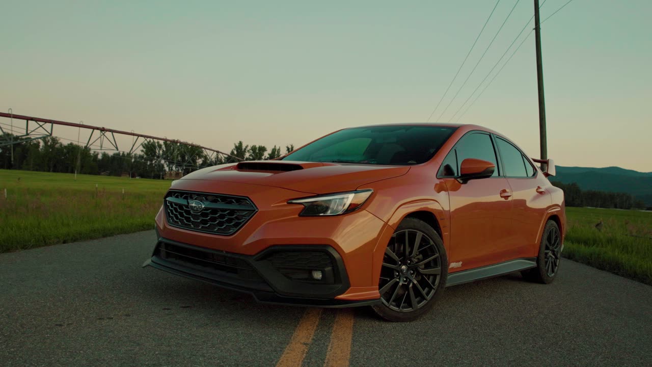 Orange WRX front three-quarter at golden hour